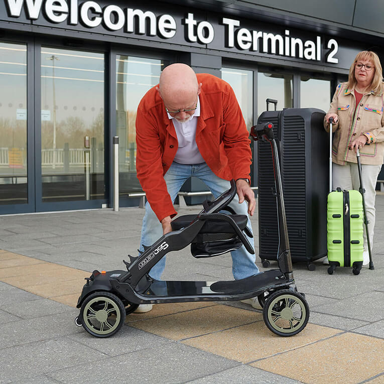 A man folding the s50 carbon folding mobility scooter