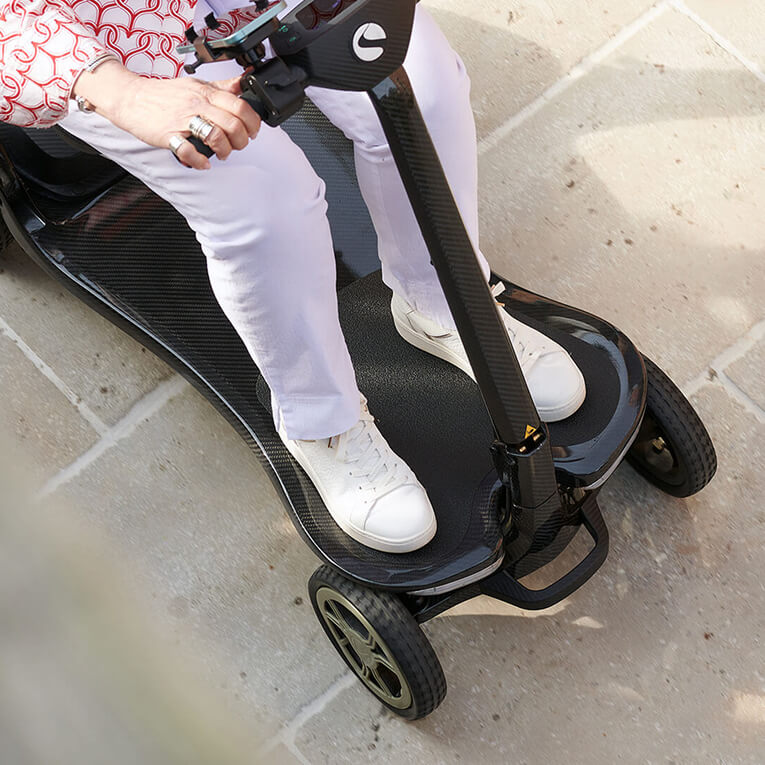 A woman driving the s50 carbon folding mobility scooter