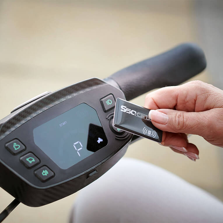 A woman starting a s50 carbon folding mobility scooter